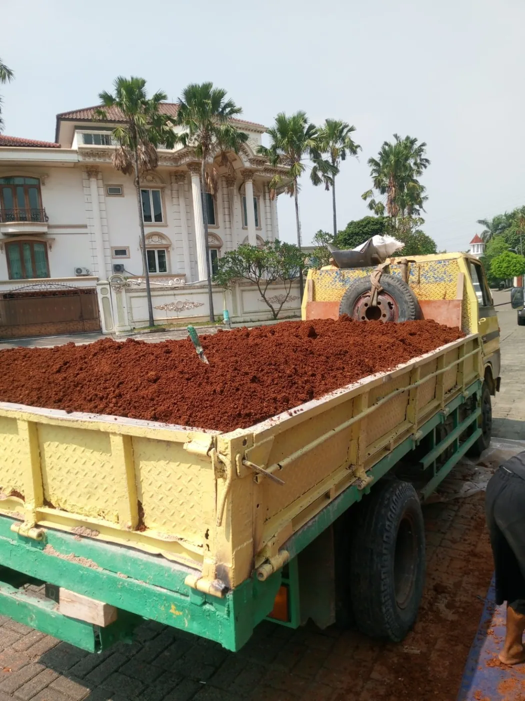 Truk membawa tanah merah